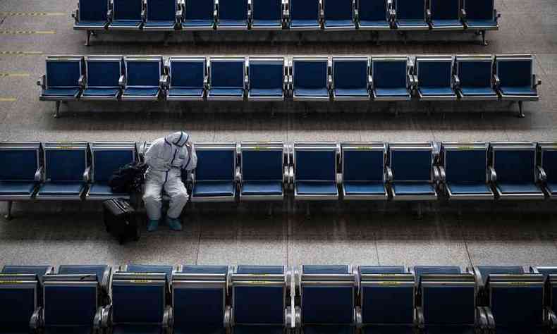 Homem espera trem em uma estação de Wuhan(foto: STR/AFP)