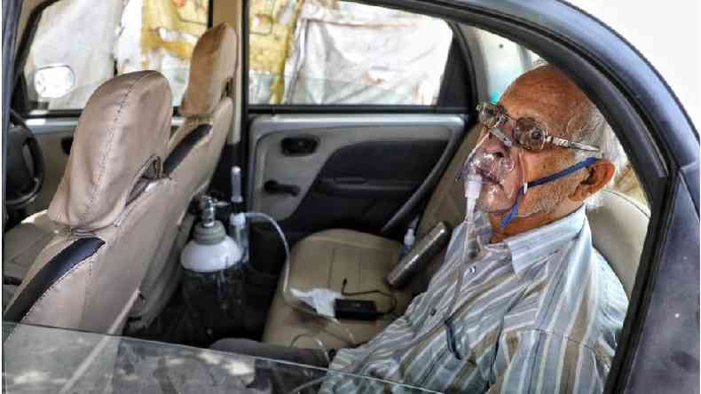 Sushil Kumar Srivastava foi fotografado sentado em seu carro, amarrado a um cilindro de oxignio na cidade de Lucknow(foto: Sumit Kumar)