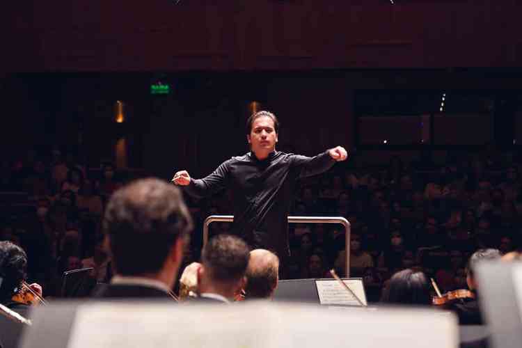 Vestido de preto, no palco, o maestro Jos Soares gesticula, regendo a Orquestra Filarmnica de Minas Gerais