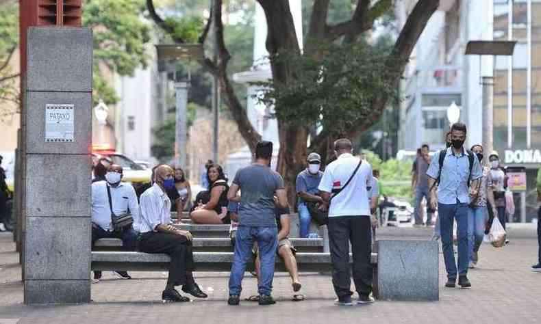 Praça Sete de Setembro, no Centro de Belo Horizonte, com pessoas circulando pelas ruas e sentadas em bancos