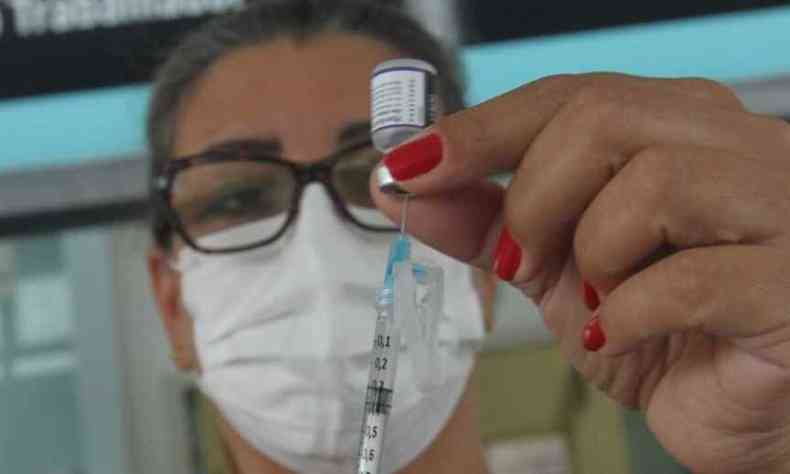 Enfermeira segurando seringa de vacina da Pfizer
