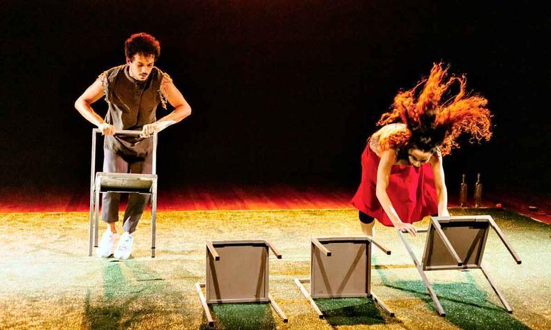 Bailarino e bailarina interagem com cadeiras em cena de Outono