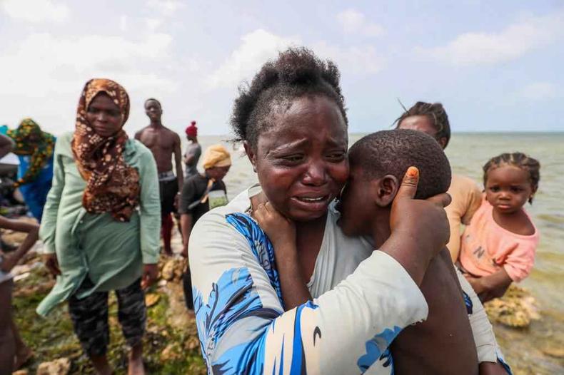 Me migrante da frica, presa  beira-mar na fronteira entre a Lbia e a Tunsia, chora segurando seu filho, em 26 de julho de 2023