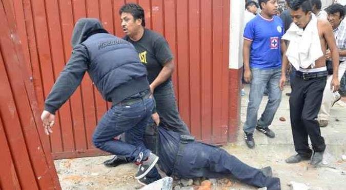 Pessoas carregam policial ferido em confronto com popula��o de vilarejo na periferia da Cidade do M�xico(foto: REUTERS)