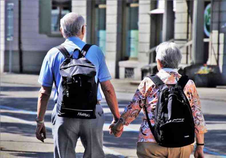 Casal de idosos viaja com mochilas nas costas