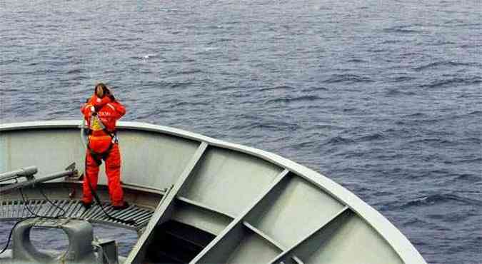 Membro da equipe do navio australiano HMAS Success procura por destroos do avio(foto: REUTERS/Australian Defence Force)