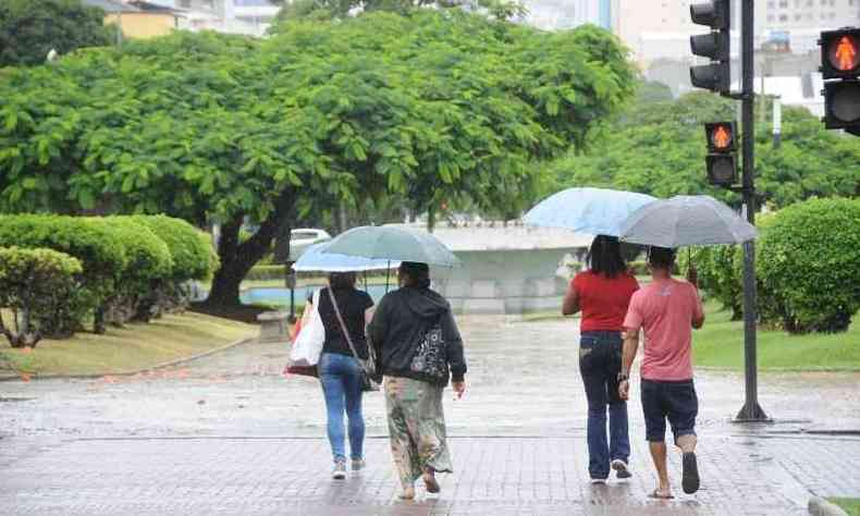Com sombrinhas, pessoas se abrigam da chuva na Praa Raul Soares, em BH 