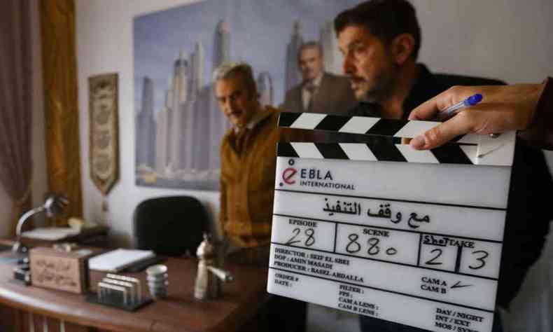 Tcnico segura claquete e ao fundo esto os atores Abbas Al-Nouri e Yazan Al-Khalil, que vo gravar a serie Pena suspensa, produo siria, em set nos arredores de Damasco