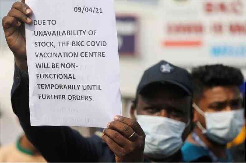 Um guarda segura um aviso para informar s pessoas sobre a escassez de suprimentos de vacina contra o coronavrus(foto: Reuters)