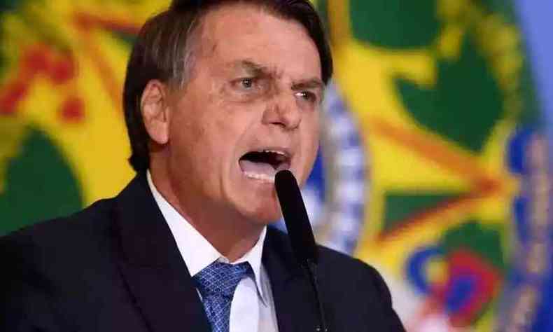 Jair Messias Bolsonaro grita para um microfone