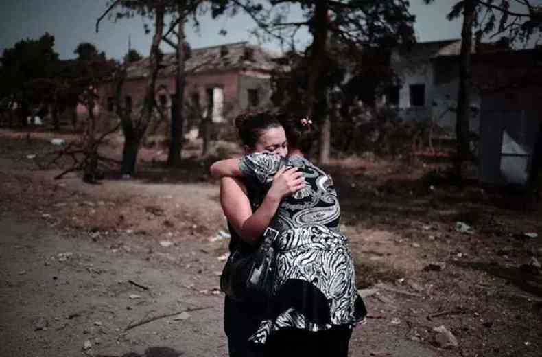 Foto, tirada em agosto de 2008, mostra mulher chorando após ter a casa destruída por uma bomba 