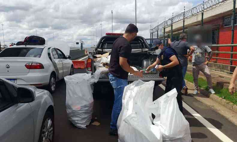 Policiais revistam carga de produtos irregulares em carro na beira da estrada