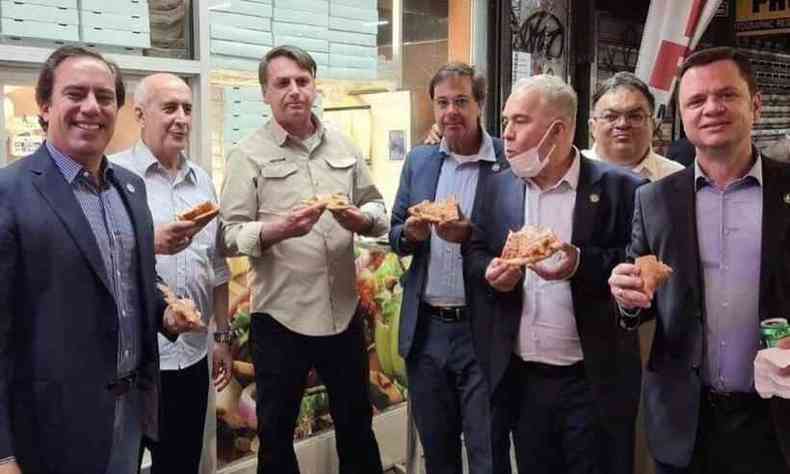 As imagens do presidente e seus auxiliares comendo pizza na calada foram publicadas pelo ministro do Turismo, Gilson Machado, nas redes sociais