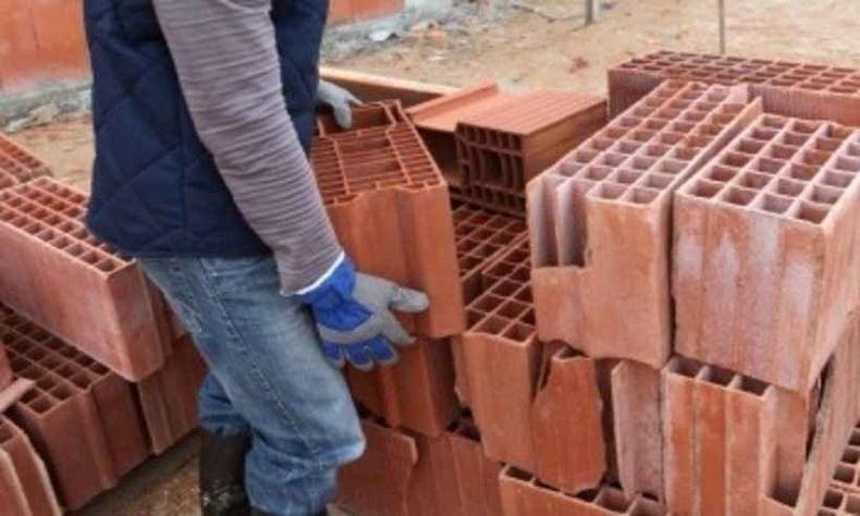 Além do racismo e da xenofobia, sofreu acidente de trabalho e foi espancado por um colega no local de trabalho(foto: TRT/Reprodução) Imagem meramente ilustrativa de um pedreiro carregando tijolos