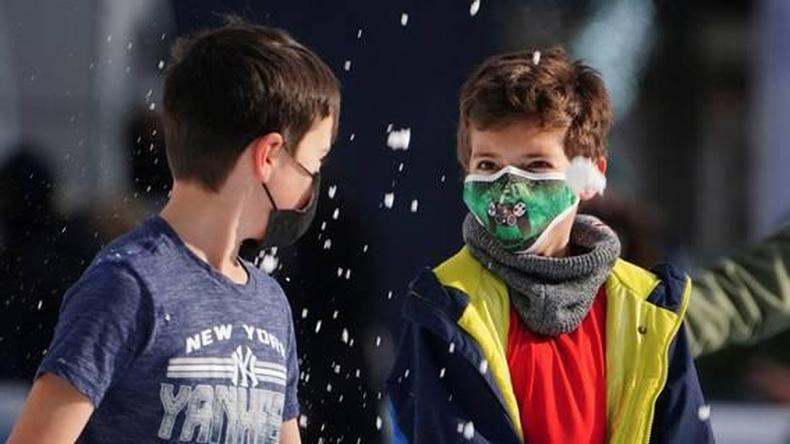 Meninos com mscaras brincam na neve