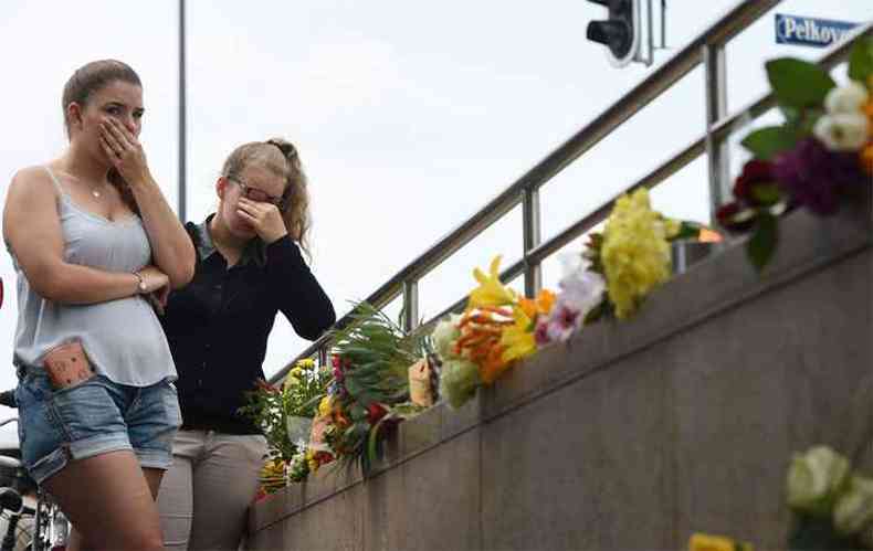 Jovens lamentam mortes. Autor do massacre se suicidou aps abrir fogo nas imediaes de shopping, matando 9 e ferindo 16 (foto: AFP / Christof Stache )