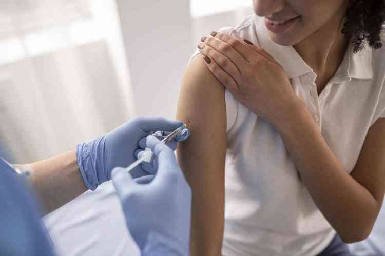 Mdico vacinando menina no brao