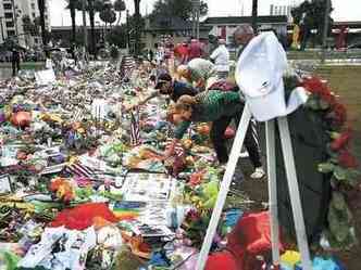 Pessoas colocam bandeiras e outros objetos em memorial no caminho da casa noturna Pulse(foto: Spencer Platt/AFP)