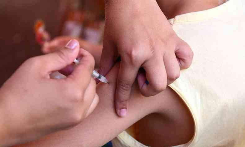 Imagem mostra criana tomando vacina