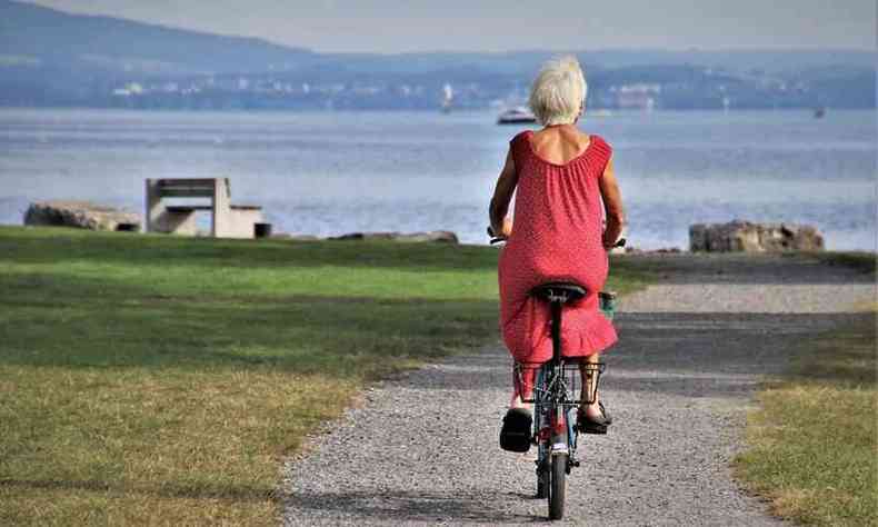 idosa andando de bicicleta em direo ao mar