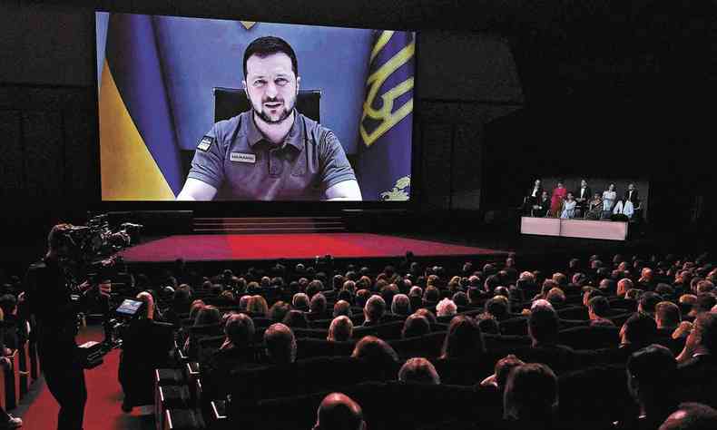 Imagem de Volodymyr Zelensky aparece em telo do Palcio dos Festivais de Cannes, com a plateia repleta de espectadores 