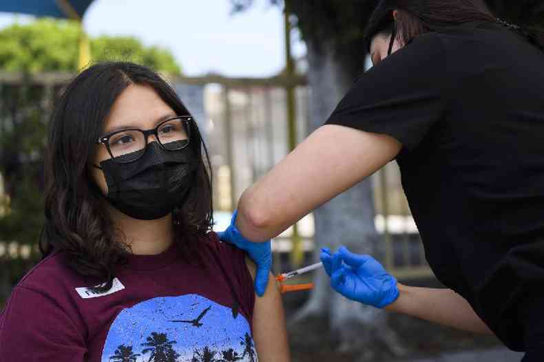 Imagem mostra jovem sendo vacinada