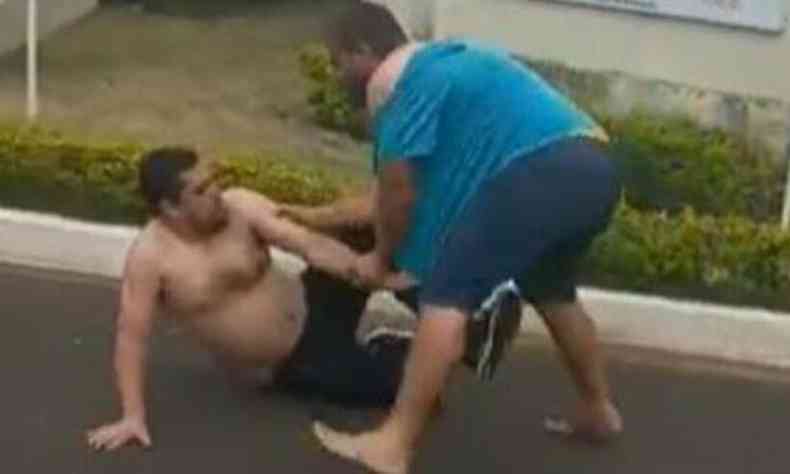 Foto retirada do vídeo mostra os dois homens em luta; o repórter está sem camisa e caído no asfalto