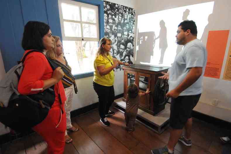 Cinco integrantes da famlia Maciel observam mquina antiga, em caixa de madeira, no Museu Ablio Barreto, em BH