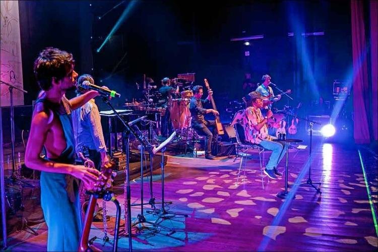 Jos Ibarra est  esquerda junto da banda Dnica e canta no palco