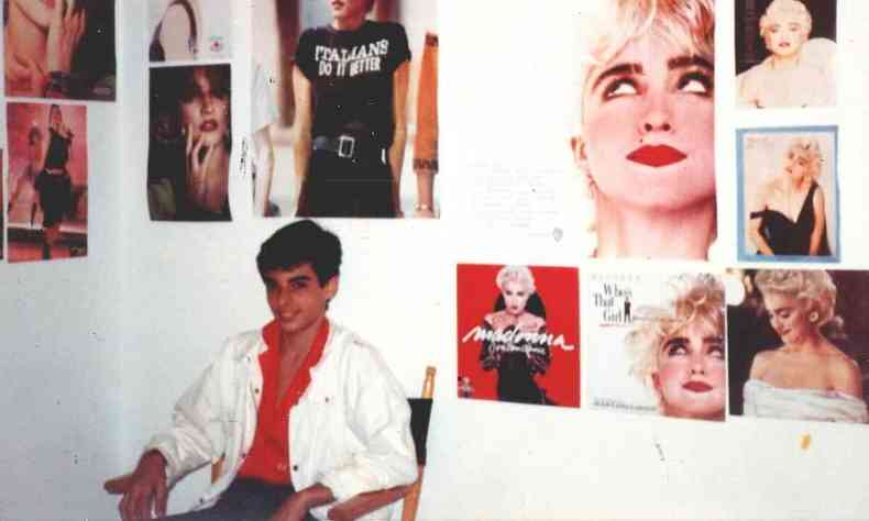 O adolescente Hprcio Brando est sentado, rodeado de posteres de Madonna