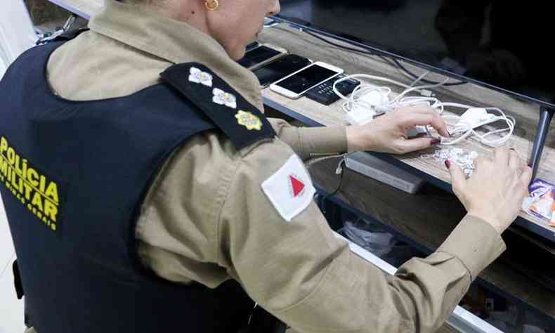 A major Layla Brunella, da PMMG, faz a contagem dos chips apreendidos em poder de um dos criminosos
