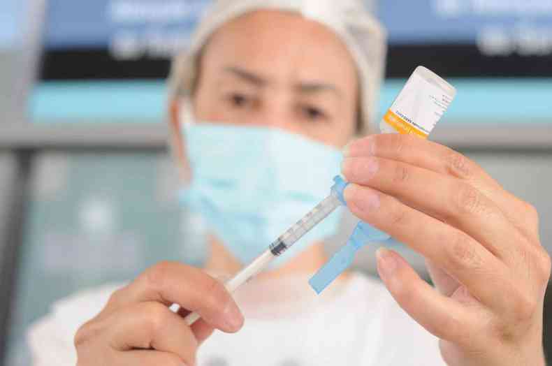 Profissional prepara a seringa com a vacina da covid-19 