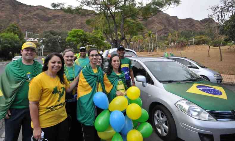 Alexandra Oliveira usa camisa amarela e est ao lado de pessoas com bandeiras do Brasil