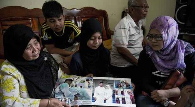 Fam�lia rev� fotos de familiar desaparecido enquanto aguarda informa��es(foto: MOHD RASFAN/AFP)