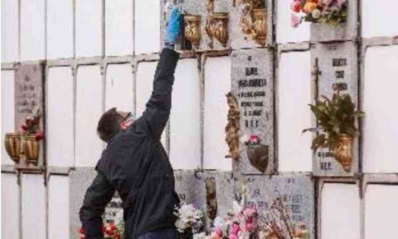 Homem presta homenagem a morto por COVID-19(foto: AFP / BALDESCA SAMPER)