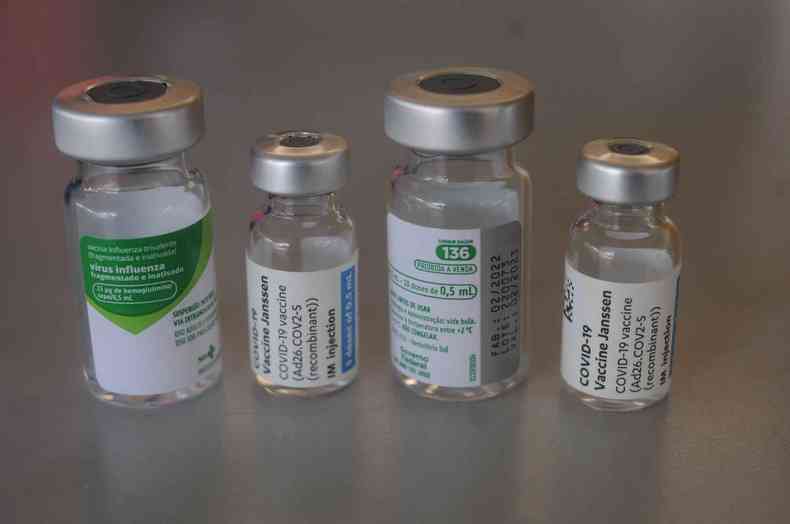 Quatro ampolas de vacina, contra a COVID e Influenza