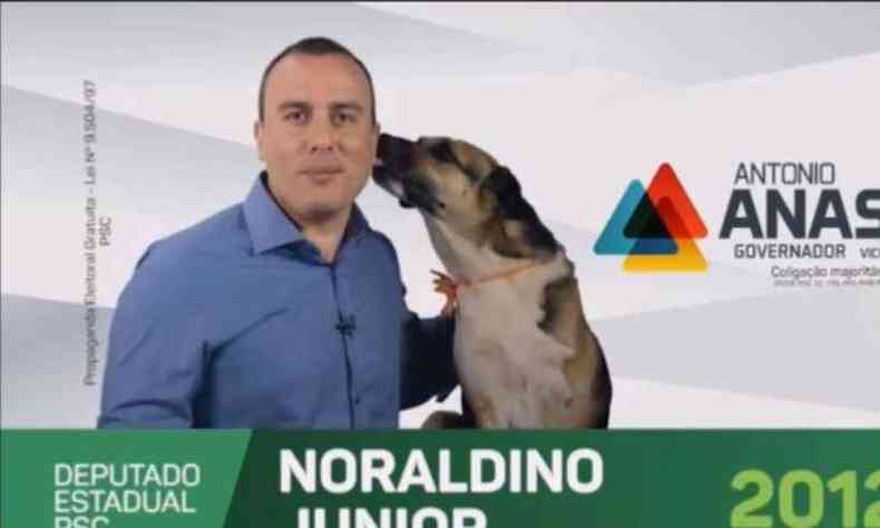 O deputado estadual Noraldino Junior aparece na TV levando uma lambida de um cachorro(foto: Reprodução)